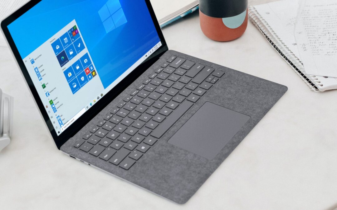 gray microsoft surface laptop computer on white table